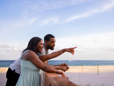Couple on a boardwalk at the beach during sunset in Orange Beach
