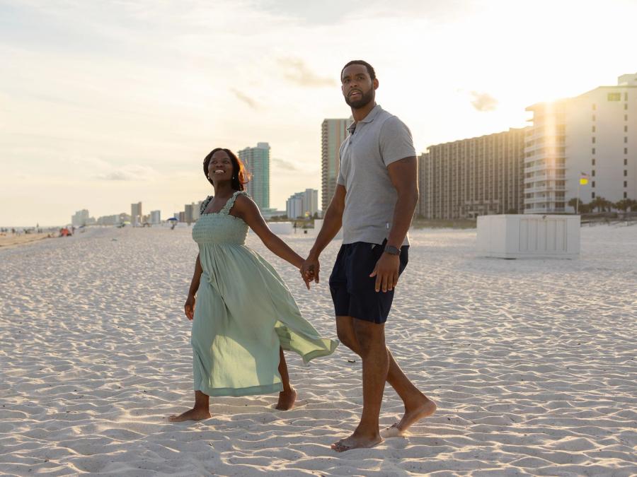 Couple walking on the beach at sunset in Orange Beach