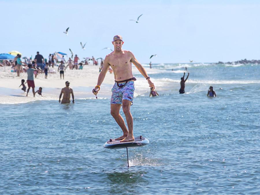 Man riding a foil board near the shore in Orange Beach