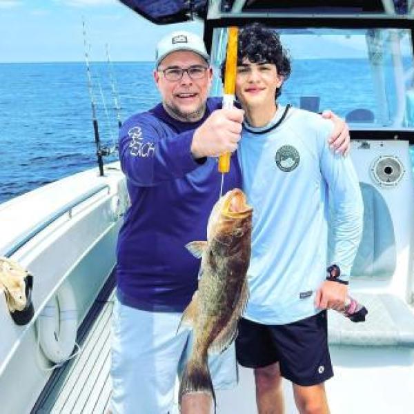 Dad and son on a fishing charter trip in Orange Beach